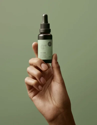 Dłoń trzymająca butelkę naturalnego olejku CBD 10% - certyfikowana jakość, full spectrum